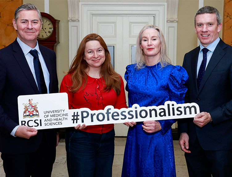 Professor Denis Harkin, Dr Rachel Clarke, Dr Suzanne Crowe and Professor Barry McGuire pose together holding a large sign that says 'Professionalism'. 