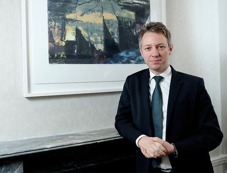 Robert Byrne standing at a fireplace