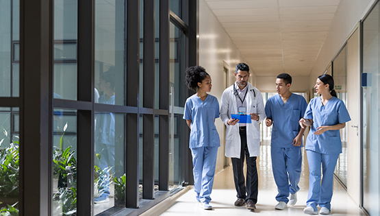 Doctor and trainees in hospital hallway