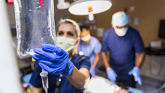 Surgical nurse hangs bag of saline
