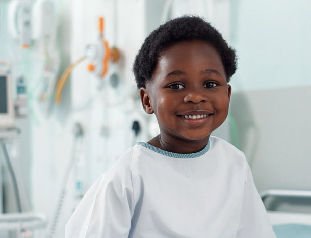 Young patient in white gown smiling in hospital